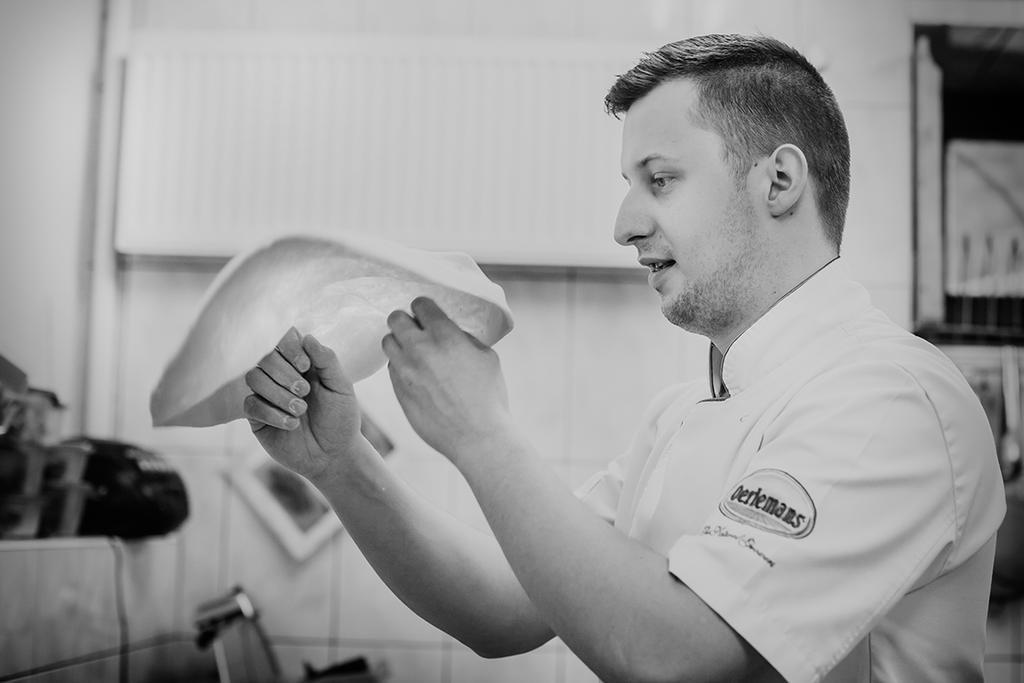 Niebieski Art Hotel & Spa Cracóvia Exterior foto A chef preparing a pizza